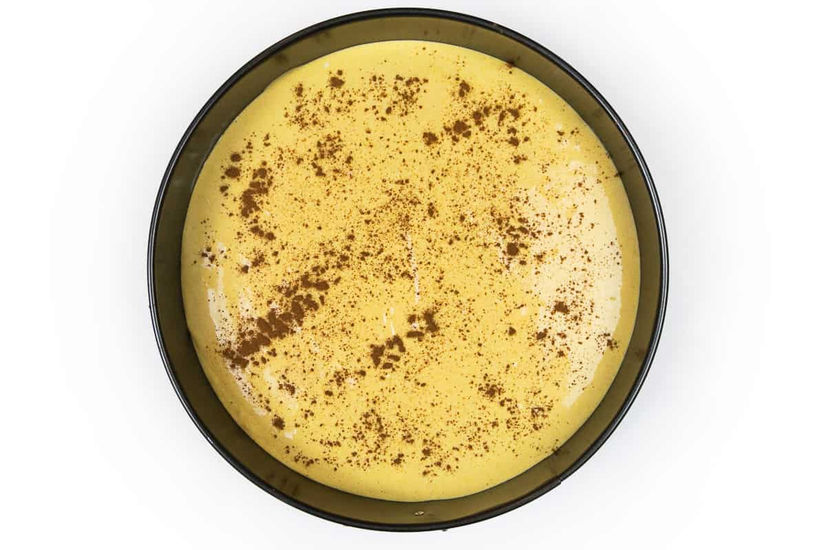 Sprinkle cinnamon on top of the pumpkin cheesecake batter.