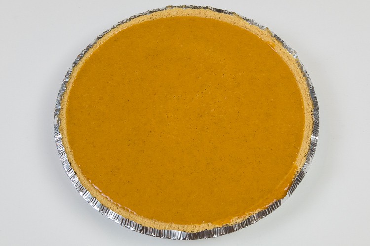 Pumpkin filling poured into a pie shell.