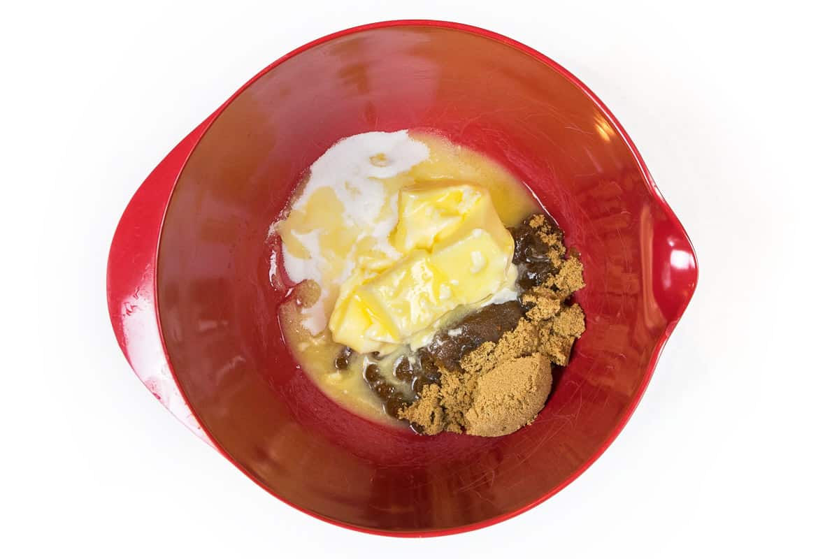 Melted butter, granulated sugar, and light brown sugar in a bowl.