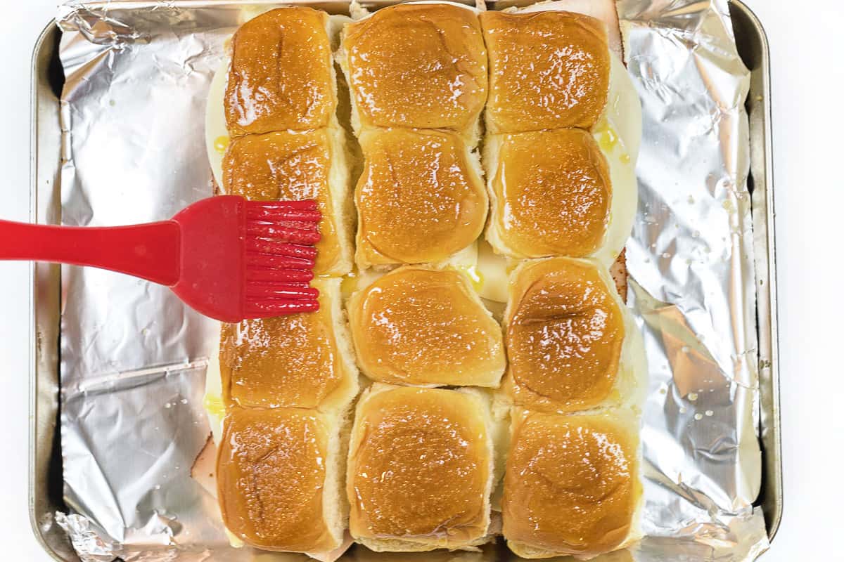 Brush the melted butter and garlic powder over the tops of the rolls.