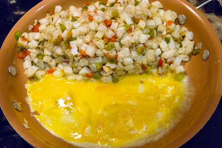 Beaten eggs are added to the frying pan.