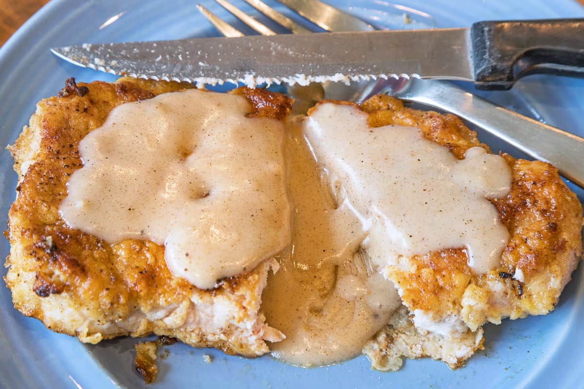 Southern country gravy poured over fried pork chops.