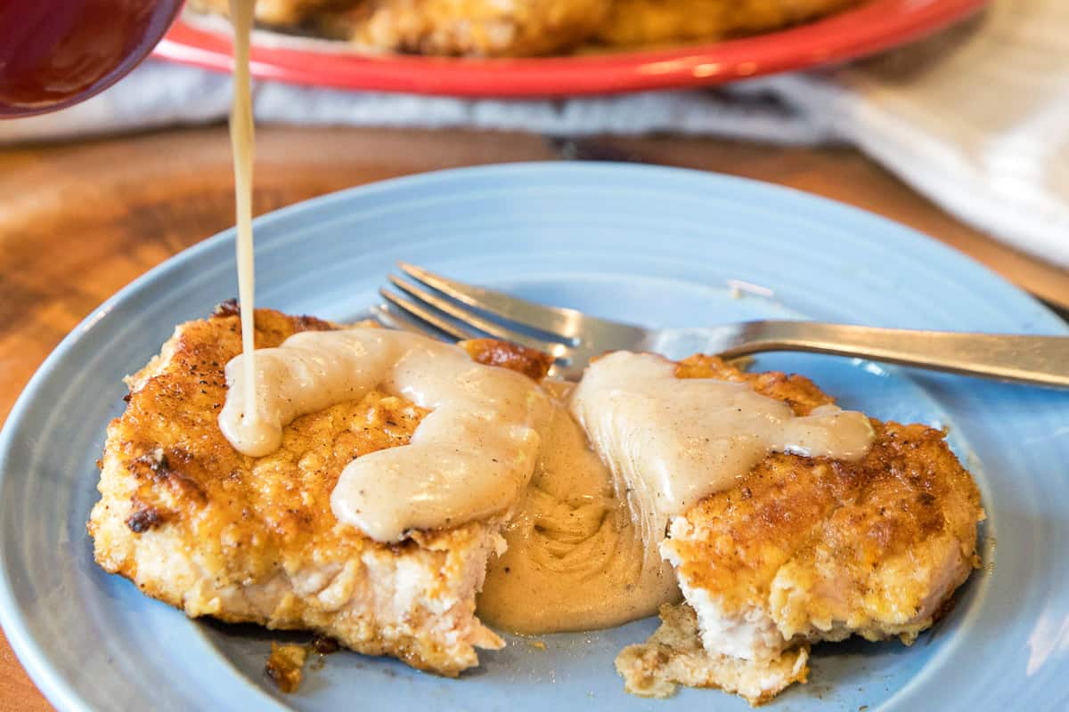 Southern country gravy poured over fried pork chops.