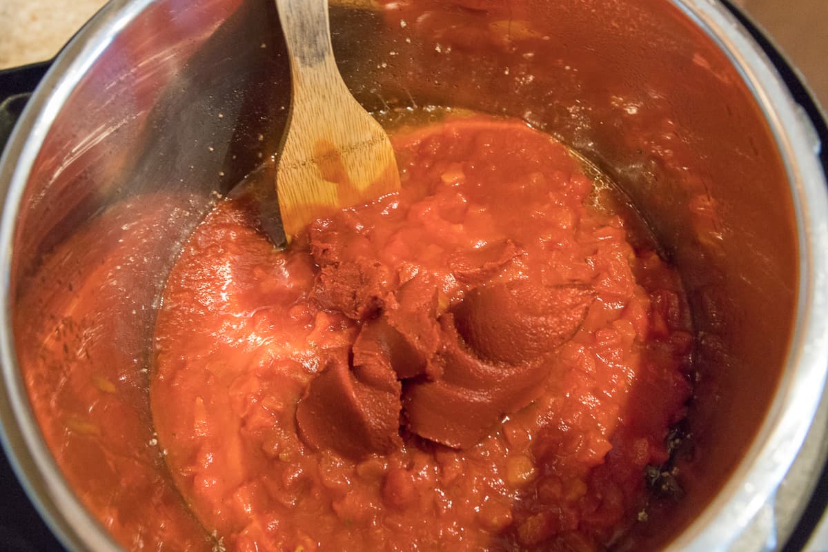 Diced tomatoes, tomato paste, and tomato sauce are added to the browned ground beef.