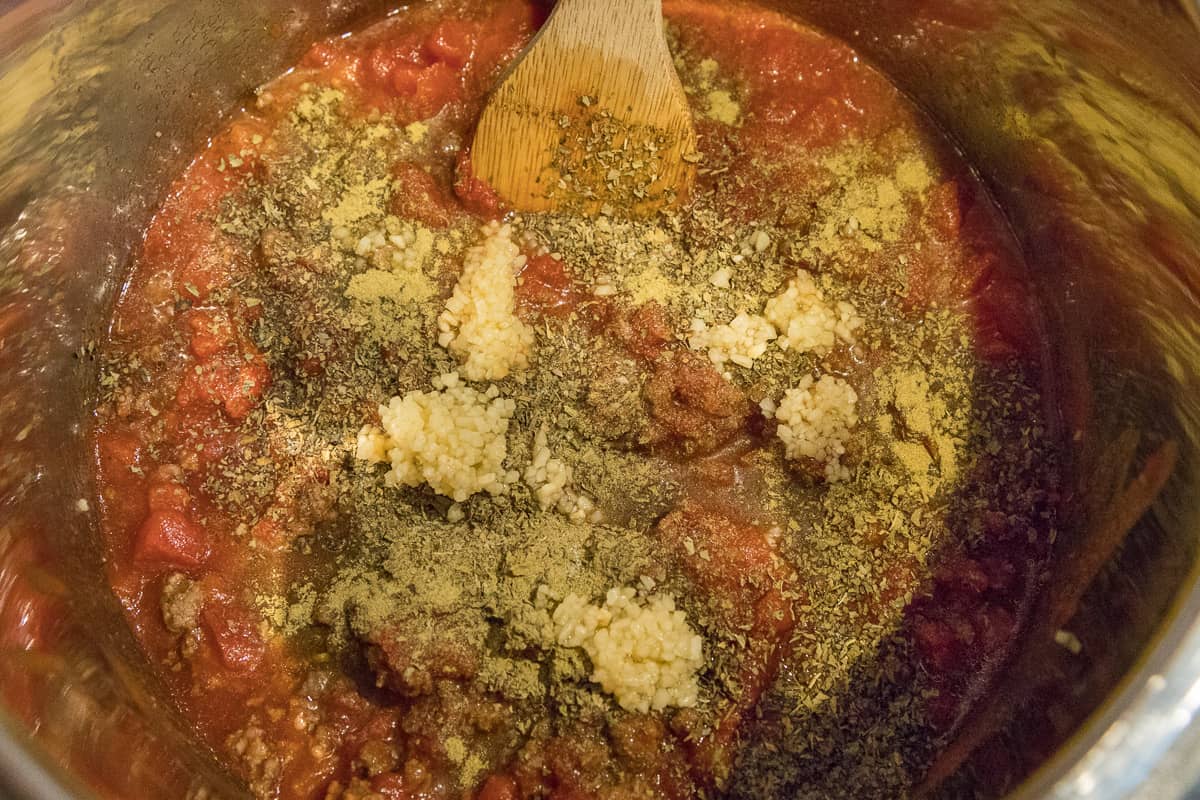 This photo shows adding the seasonings to the spaghetti sauce mixture.