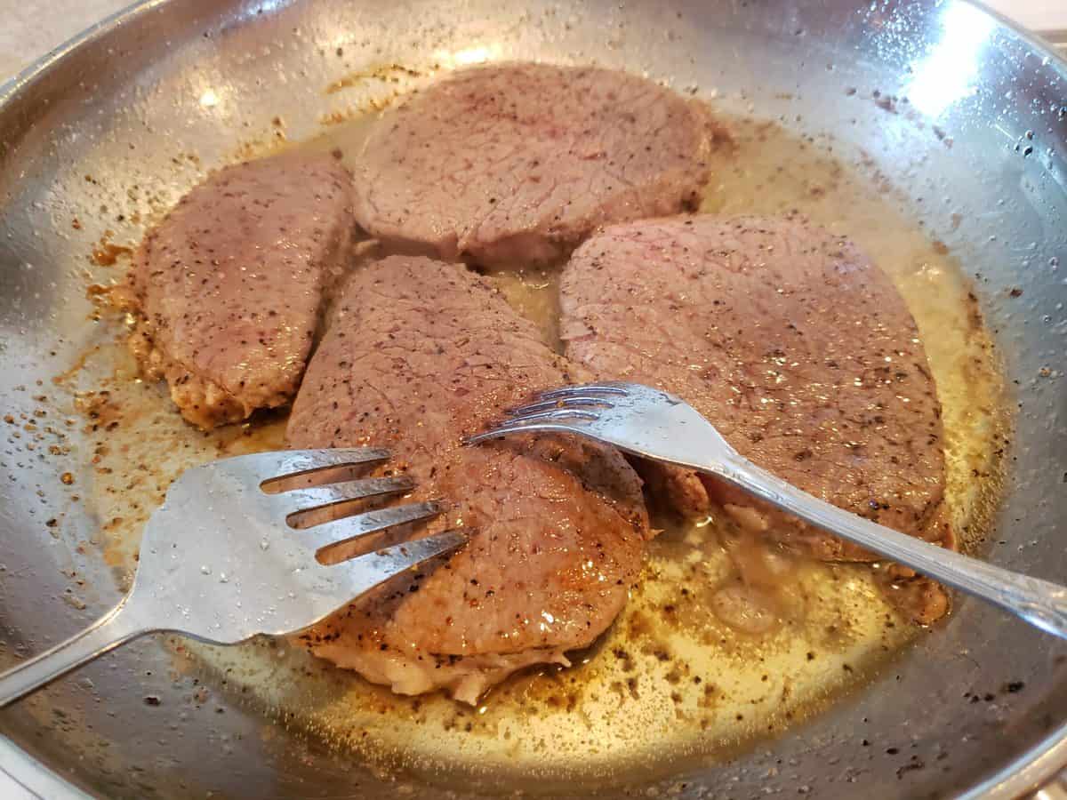 Poke the steaks with a fork.