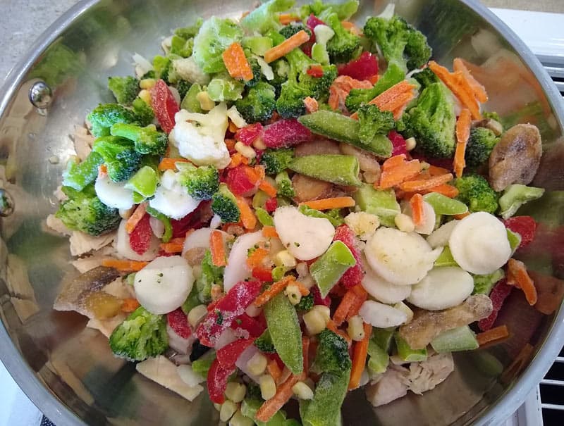 Vegetables are added to the frying pan.