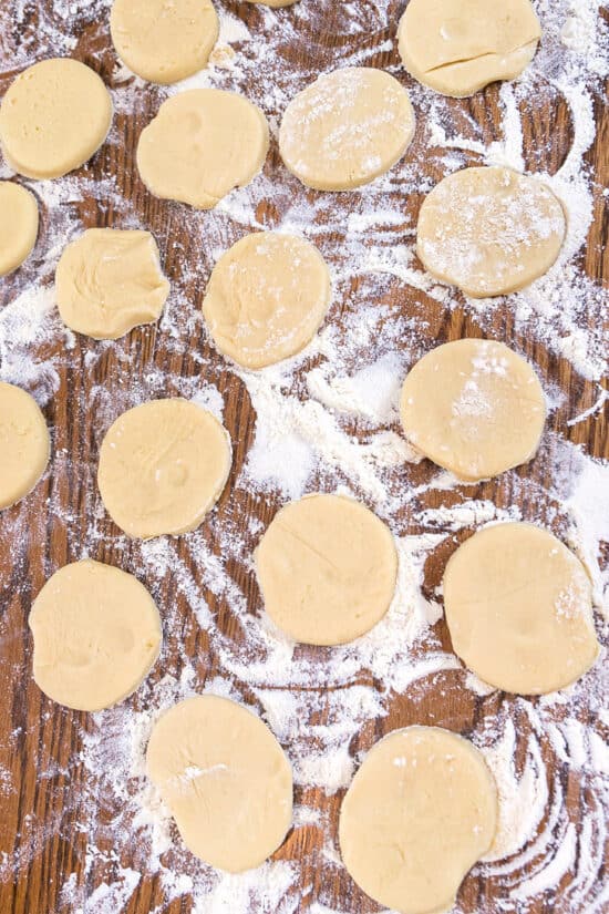Cookie dough shapes on a floured surface.