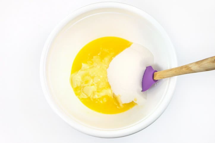 Stir melted butter and sugar together in a bowl.