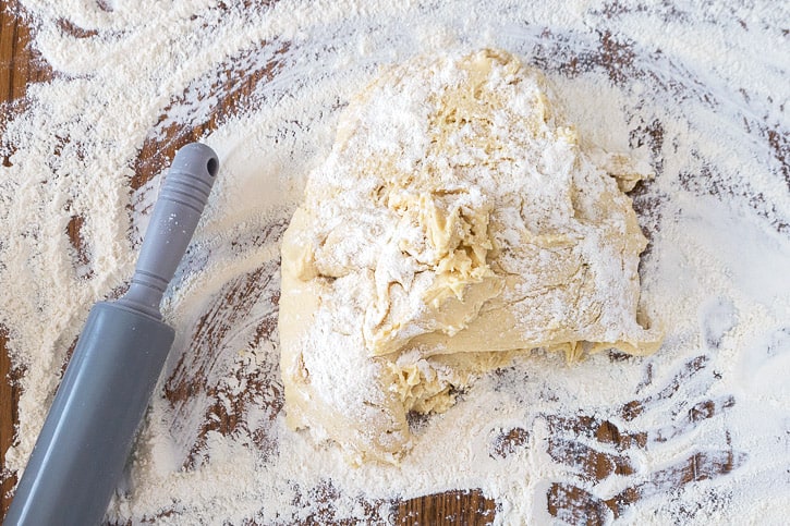A ball of cookie dough on a floured surface.