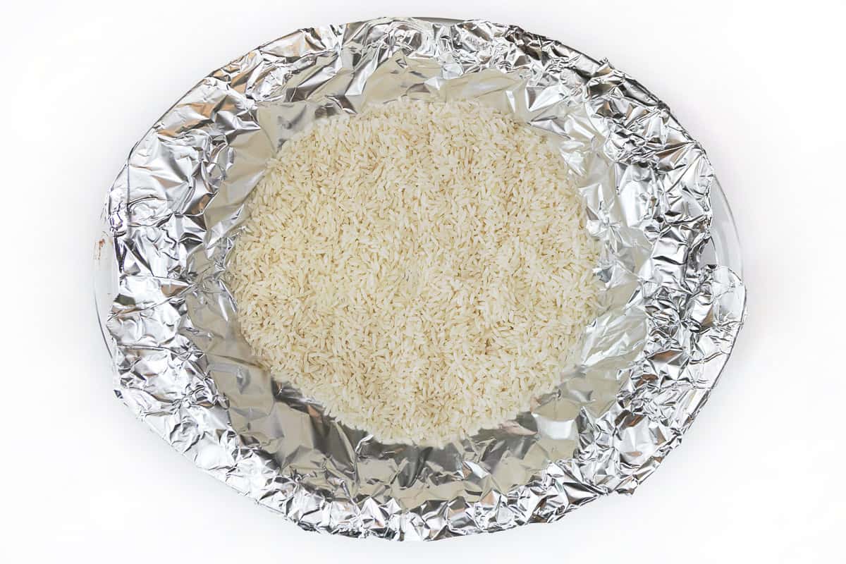 Rice is poured over the aluminum foil.