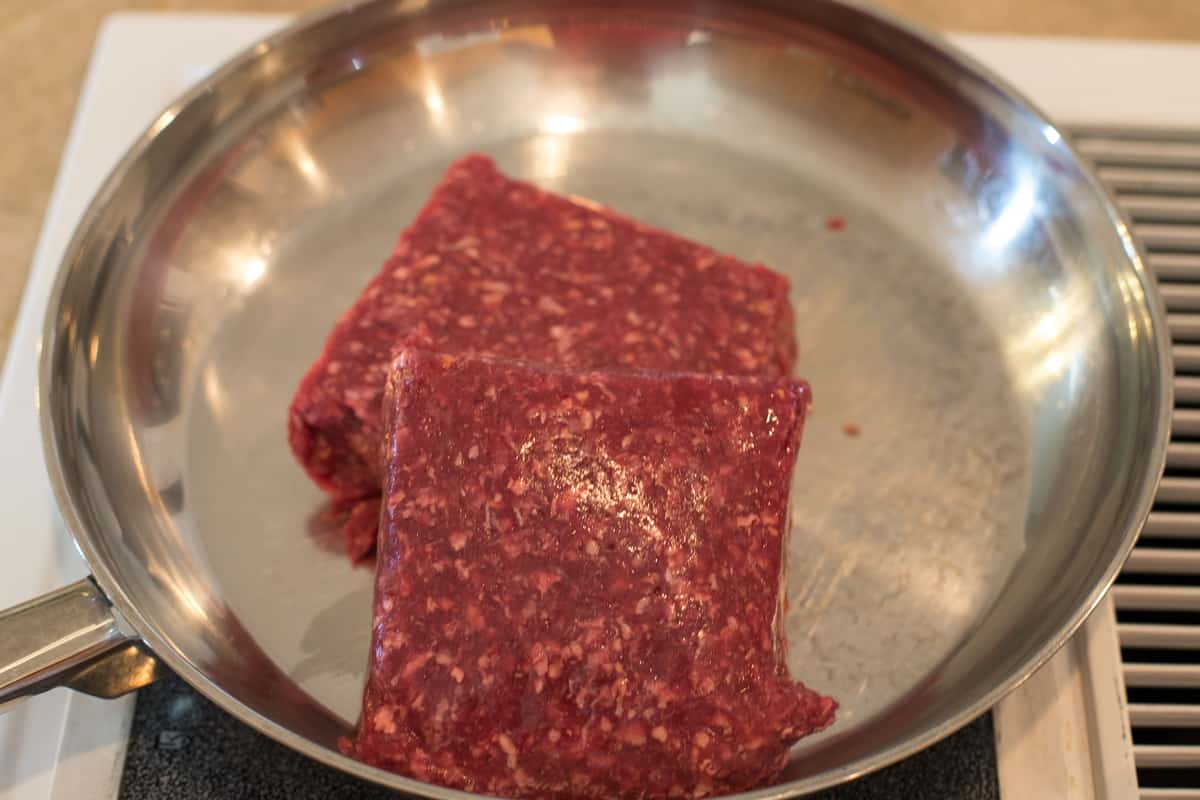 Two pounds of ground beef in a frying pan.