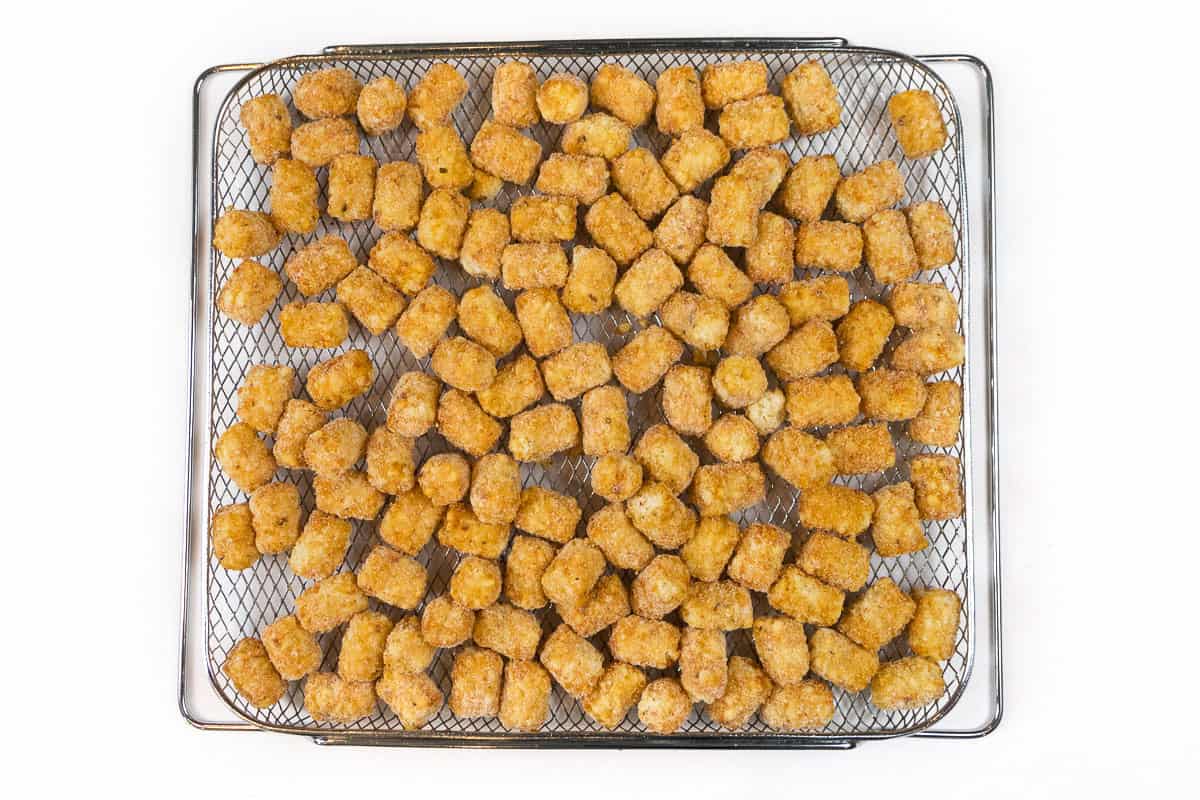 Arrange the tater tots in the air fryer basket. Sprinkle with Johnny's seasoning salt.