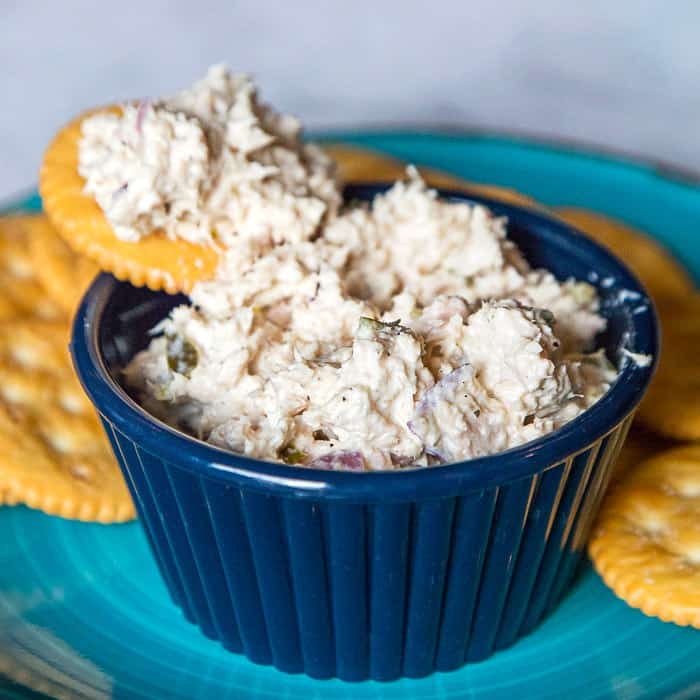 Tuna salad in a bowl with Ritz crackers on the side.