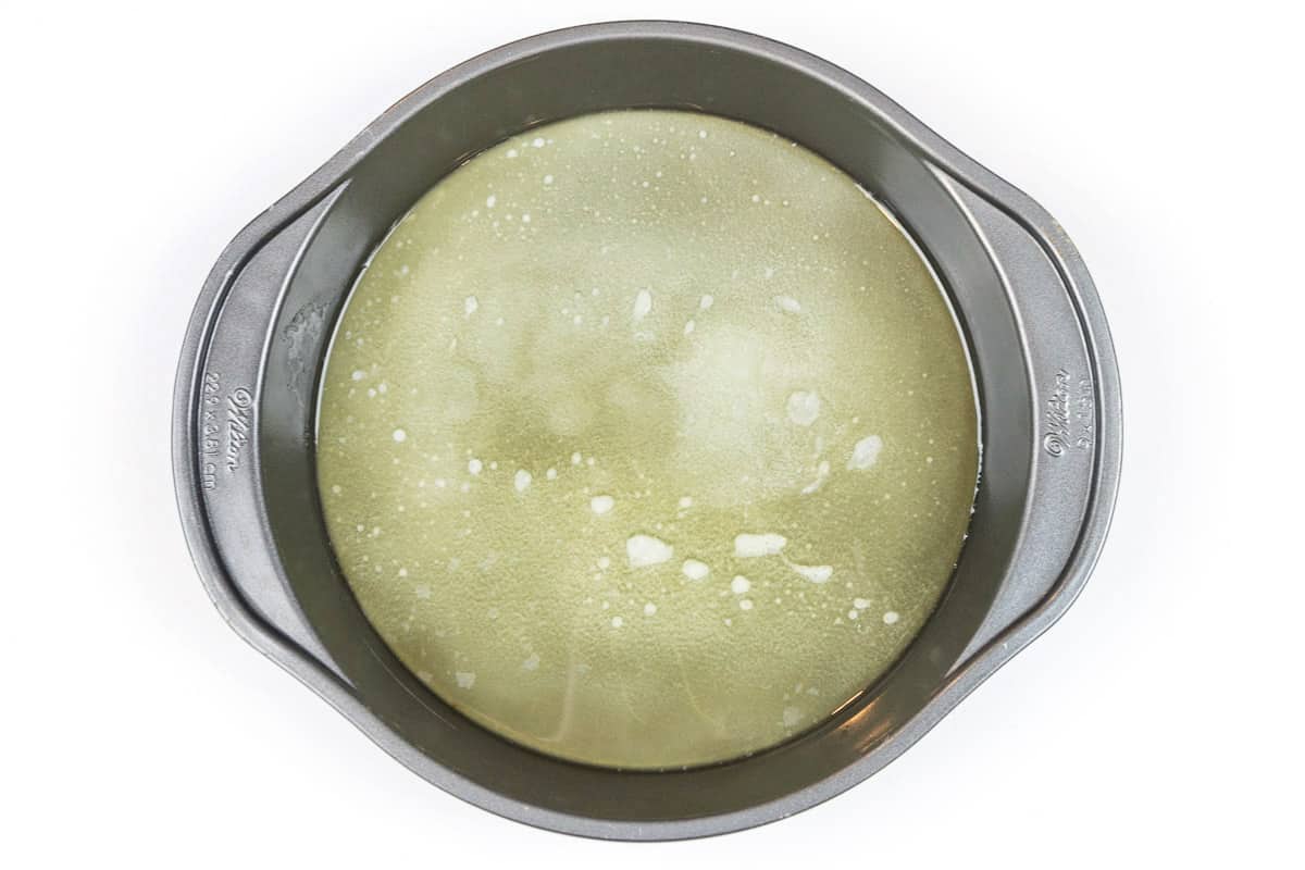 Coat a nine-inch round cake pan with melted butter on the bottom and sides of the cake pan.
