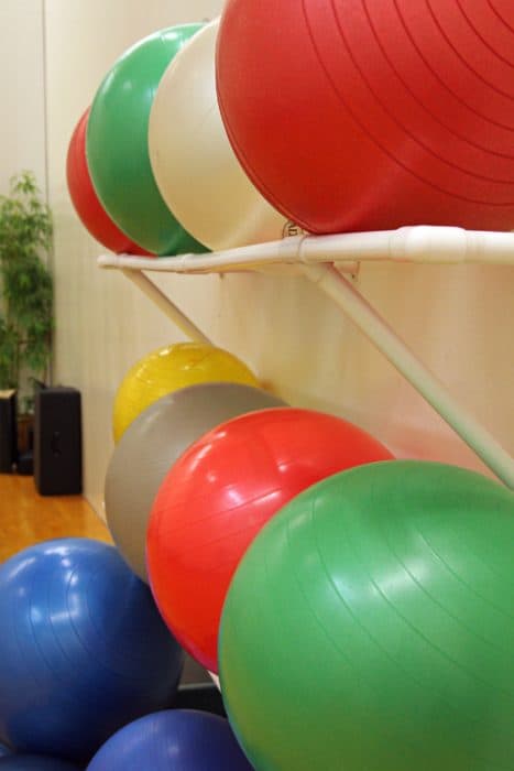Yoga balls on a shelf in a gym.